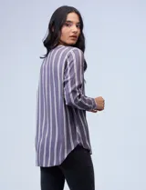 Camisa celeste con rayas verticales blancas y azules, cuello mao, escote en V y cierre frontal con botones.