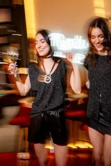 Blusa negra de lurex con tajo en la parte delantera y corte suelto.