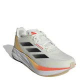 Championes de running Adidas modelo Duramo Speed, color beige con detalles en negro y naranja. Presentan una parte superior de malla transpirable, amortiguación Lightstrike en la entresuela y suela de goma resistente.