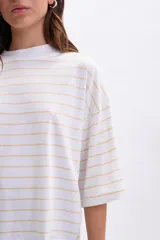 Remera de manga tres cuartos, corte holgado, color blanco con finas rayas horizontales en tono amarillo pálido. Presenta cuello alto tipo mock neck.