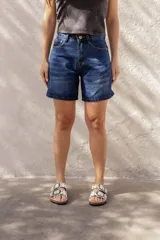 Short de jean largo, tiro alto, color negro lavado con efecto desgastado. Presenta un corte recto y holgado, con cierre de botón y cremallera.