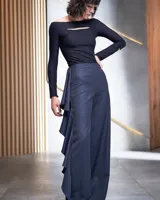 Pantalón de gabardina de lana color azul marino, de tiro alto y corte palazzo. Presenta un volante en espiral en uno de los laterales.