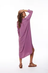 Vestido camisero midi color lila, de corte recto, con cuello camisero, mangas 3/4, cierre frontal con botones y aberturas laterales.
