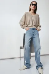 Pantalón de jean celeste de tiro alto, corte recto y largo hasta el tobillo. Tiene cinco bolsillos, trabillas en la cintura, efecto lavado y cierre frontal con cremallera y botón.