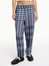 Pantalón largo a cuadros azules y grises, de pierna recta y tiro medio. Tiene pretina con elástico y bolsillos laterales.