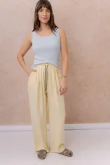 Pantalón amarillo de corte amplio y pierna recta, confeccionado en tela liviana con caída fluida. Cuenta con cintura elastizada, cordón regulable en contraste y bolsillos laterales.