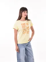 Remera negra de algodón con estampado frontal de la palabra "MERCI" en letras delineadas con colores del arcoíris.