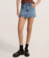 Minifalda de denim de tiro medio, color celeste claro, con tachas metálicas aplicadas en los bordes de los bolsillos delanteros y trabillas.