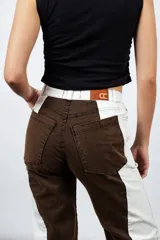 Pantalón de jean marrón chocolate con paneles laterales blancos, tiro medio, calce recto y lavado semi ácido.