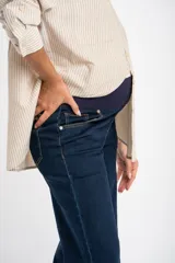 Jean de corte flare wide leg con tiro medio y ruedo desflecado. Confeccionado en denim de algodón, presenta un tono azul oscuro uniforme con costuras en contraste.