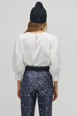 Pantalón sastrero de tiro alto con estampado de leopardo en tonos azulados, corte carrot, cintura ceñida con pliegues frontales, bolsillos laterales y bolsillo de ojal trasero.