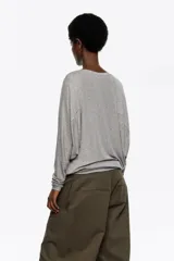 Camiseta de modal y poliéster color gris melange, con escote barco, mangas ranglán estilo murciélago y puños largos ajustados.