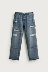 Jeans relaxed fit de tiro medio y pernera recta confeccionados en denim de algodón rígido, con diseño de carpintero que incluye bolsillos superpuestos y roturas localizadas en el frente.
