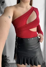 Mini pollera negra de cuero sintético con tablas y cierre lateral.