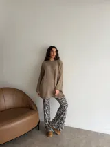 Conjunto compuesto por un buzo de punto acanalado en color beige con cuello redondo y mangas largas holgadas, y un pantalón tipo oxford de tiro alto con estampado animal print de leopardo.