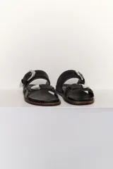 Sandalias marrones de cuero con dos tiras anchas sobre el empeine, hebillas plateadas y pespuntes en contraste.