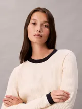 Remera de manga larga Calvin Klein confeccionada en tejido waffle de color beige, con cuello redondo y puños en contraste de color negro. Presenta un pequeño parche con el logo de la marca en el lateral inferior.