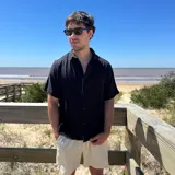 Camisa de lino negra con corte boxy, manga corta y cuello camisero. Presenta un estampado gráfico en la espalda compuesto por tres círculos alineados verticalmente.