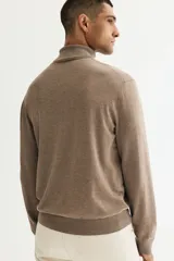 Buzo de punto fino con cuello alto acanalado, manga larga y terminaciones acanaladas en puños y bajo.