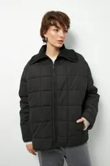 Campera marrón capitoneada de manga larga con cuello alto de tela, cierre frontal y bolsillos laterales con cierre.