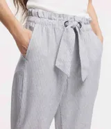 Pantalón baggy de sarga con diseño de rayas verticales, cintura alta elástica con lazo ajustable, bolsillos laterales y corte recto ligeramente cropped.