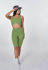 Conjunto deportivo de dos piezas color verde oliva, compuesto por un top deportivo con cuello redondo y logo estampado en el frente, y calzas cortas tipo biker de tiro alto.