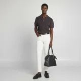 Pantalón chino de hombre, color blanco crudo, de corte slim y tiro medio, con cinco bolsillos y cierre de cremallera.