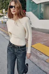 Jersey de punto color verde lima, con cuello pico y manga larga de sisa ancha que se estrecha hacia la muñeca.