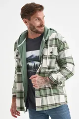 Camisa de franela a cuadros en tonos verde, blanco y marrón, con botones frontales y bolsillos en el pecho.