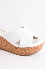 Sandalia color beige con plataforma de corcho y tiras cruzadas de cuero.