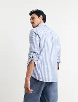 Camisa de lino a rayas verticales color beige y blanco, de corte clásico, con cuello abotonado y mangas largas.