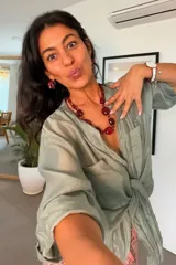 Camisa de seda blanca de corte holgado, con mangas tres cuartos con trabilla para arremangarlas, cuello camisero, cierre frontal con botones y dos bolsillos en el pecho.