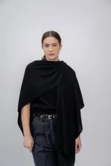Ruana negra de tejido de punto grueso, confeccionada en 100% baby alpaca.