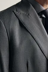 Blazer regular fit de Zara confeccionada en 100% lana, de color gris con diseño de rayas diplomáticas. Presenta cuello con solapas de pico, manga larga con botones en los puños, bolsillos con solapa en la cadera y bolsillo de vivo en el pecho. Cuenta con cierre frontal de botonadura cruzada.