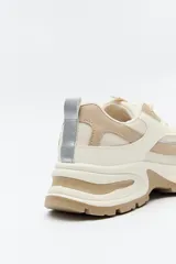 Zapatillas chunky color blanco y beige, con base robusta de 5,5 cm de altura.