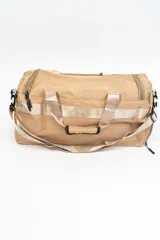 Bolso de viaje gris con doble asa corta y cierre superior. Estampado frontal con la frase "The Tote Bag" en letras blancas.