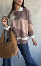 Sweater de punto con diseño de bloques de color en tonos tierra y beige, de corte oversize, cuello redondo y manga larga.