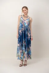 Vestido largo de seda plisada con estampado floral en tonos azules y rosados, tirantes finos y escote en V.