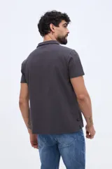 Remera polo verde militar con textura sutil, de manga corta, cuello camisero y cierre frontal de botones.