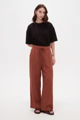 Pantalón de algodón color terracota, de tiro alto y calce holgado, con cintura elástica con cordón ajustable y bolsillos frontales aplicados.