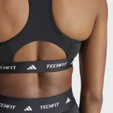 Top deportivo Adidas Techfit negro con logo blanco y banda elástica con la inscripción "TECHFIT" en blanco.
