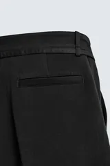 Pantalón de corte balloon fit en color gris, confeccionado en tejido con viscosa. Presenta pliegues frontales, cintura con cinturón integrado a contraste, bolsillos laterales y bolsillos traseros de vivo.