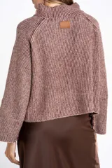 Polera de punto acanalado con cuello alto, diseño holgado y mangas largas con corte raglán.