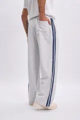 Pantalon deportivo gris melange de corte holgado, con franjas laterales en color azul marino.