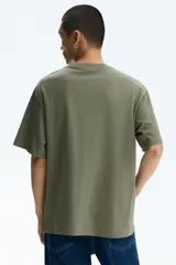 Remera de algodón verde militar con cuello redondo y estampado frontal con texto en color gris.
