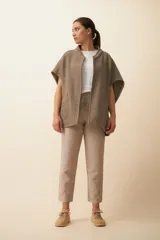 Chaleco marrón de lana con cuello mao, solapas pronunciadas, bolsillos ojal y terminaciones envivadas.