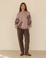 Buzo tejido de algodón y acrílico, color rosado con diseño floral en tonos marrones, de silueta amplia, cuello alto y terminaciones acanaladas.