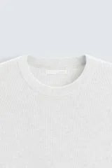 Camiseta negra de punto perlado, corte regular fit, cuello redondo, manga corta y rib en los acabados.