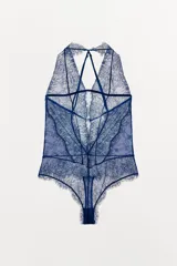 Body semitransparente de encaje azul marino con cuello halter, hombros descubiertos y tiras cruzadas en la espalda.
