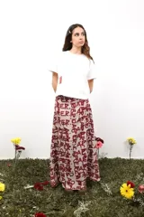 Falda larga de gasa con estampado tipográfico en color bordó sobre base beige. Presenta doble capa de tela y cierre lateral oculto.